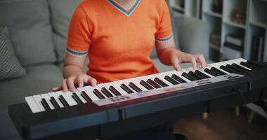 Handheld close up shot, Woman's hands are practicing playing the piano keyboard with relaxation and happiness in the living room. video