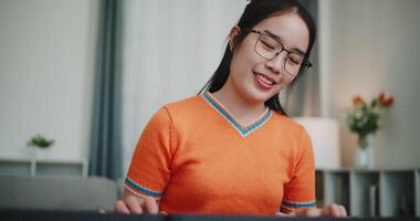 Handheld shot, Beautiful woman playing the keyboard with happy smile in cozy living room. Enjoy a relaxing weekend activity video
