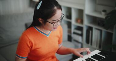 High angle view shot, Woman's hands are practicing playing the piano keyboard with relaxation and happiness in the living room at home. video