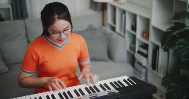 Handheld high angle view shot, A young woman is practicing her keyboard alone and enjoys a peaceful moment with music. video