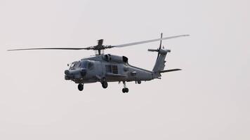 A Sikorsky MH-60R helicopter flies through cloudy skies at the Avalon Airshow in Geelong, Australia. Smooth camera tracking captures its movement video