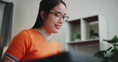 Handheld low angle view shot, Beautiful Asian woman playing the keyboard with happy smile in cozy living room at home. Enjoy a relaxing weekend activity video