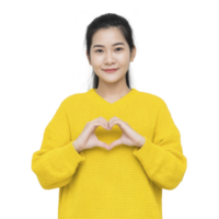 Person in yellow sweater makes heart shape with their hands, smiling warmly. background is plain, emphasizing gesture and expression png