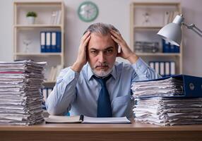 Stressed man worries about economy with holding hand and document, between stack of document 1 photo