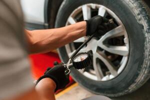 Adjusting the tire. Man is ,works in ,the automobile repairing salon photo