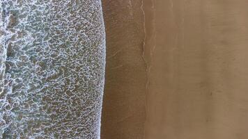 Aerial View of Waves Crashing on Sandy Beach at Lenggoksono Beach photo