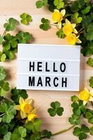 hello march sign with yellow flowers photo
