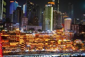 Chongqing, China-APR 02, 2025- Night view Cityscape of the famous downtown shopping complex Hongyadong with illuminated bridge and highrise building in Chongqing photo