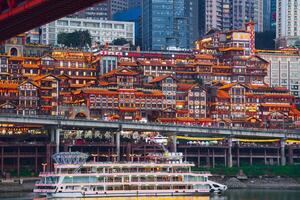 Chongqing, China- APR 02, 2025-Twilight Cityscape of the famous downtown shopping complex Hongyadong with illuminated bridge and highrise building in Chongqing, China photo