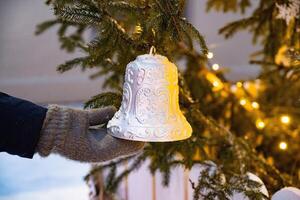 Stylish christmas illumination and fir branches with red and gold baubles, golden lights bokeh on front of building at holiday market in city street.Christmas street decor photo