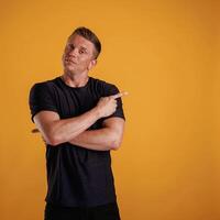 Showing to the side, pointing.,, Man ,is ,against background in the studio photo