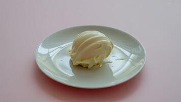 a single tortilla on a white pla te sitting on a pink surfa ce in a simple studio shot from a bove view photo