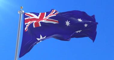Flag of Australia waving at wind in blue sky, loop video