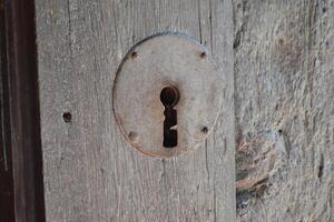 Rustic keyhole on weathered wooden door in Brihuega spain for architectural design and historic decor. Iglesia de San Felipe. Church Saint Felipe in Brihuega, Guadalajara, Spain photo