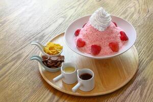 Fruity shaved ice of red strawberry or bingsu on white bowl with toppings,sauce and jam. photo