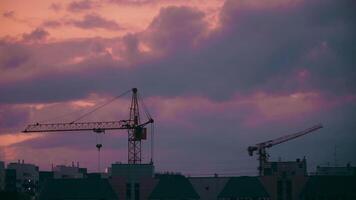Cranes on Construction Site Under Cloudy Sky. Beautiful sunset. Timelapse. video