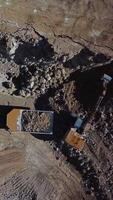Loading of stone into truck. Excavator at work. Quarry mining. Vertical video