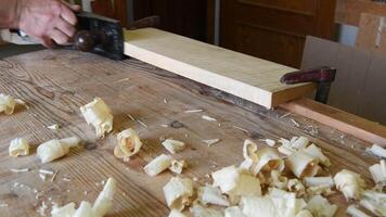 Luthier sanding a block wood with a wood planer in the workplace video