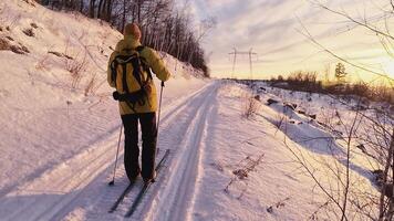 A person on skis is walking down a snowy path video