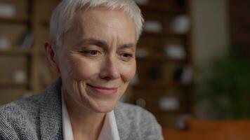 Senior woman smiling while reading good news online video