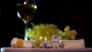 cheese white wine green grapes brie cheese with honey camera slowly moving black background dorblu cheese video