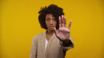 Woman Gesturing Stop with Hand Against Yellow Background video