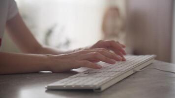 händer skriver på en vit tangentbord i en minimalistisk arbetsyta video
