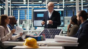 Photovoltaics plant researchers meeting to optimize energy production, analyzing solar cell prototypes. Solar panels plant specialists developing cutting edge manufacturing tech, camera A video
