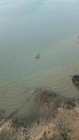 Vertical Drone shot of tropical sailboats in a turquoise bay near the harbor, boats floating in crystal clear water near a scenic Thai island with rocky beach. Picturesque shoreline with fun activities. video