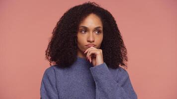 Thoughtful woman making a critical decision on pink background video