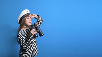 Banner of a sailor girl on a blue background teenage girl in a sailor suit with a binocular looking into the distance photo
