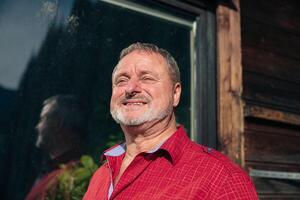 Contented Mature Man in Red Shirt Basking in the Evening Sunlight photo
