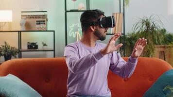 Man using virtual reality futuristic technology headset to play simulation 3D game at home video