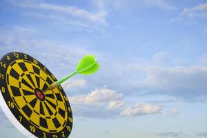 Close up shot of the dart arrow hit on bulleyes of dartboard to represent that the business reached the target of company with dark tone picture style. Target and goal as concept. photo