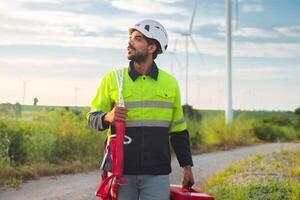 man in a yellow and black safety jacket is holding a red toolbox photo