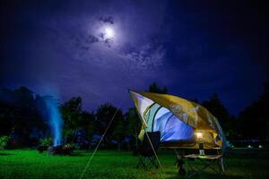 Camping tents at night in a forest Sky background with the moon, Antique lanterns photo