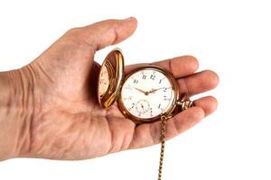 man's hand holds a vintage gold pocket watch on a white background photo
