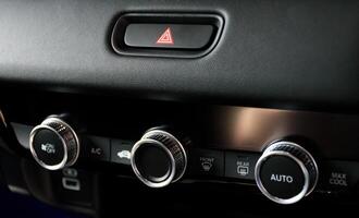 Button automatically adjust the air conditioning temperature and emergency light button in a modern car luxury interior 2024. Function control panel buttons in modern car. photo