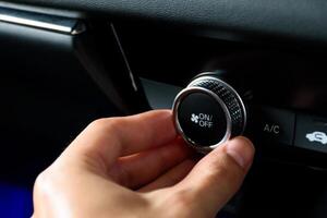 Close up hand turning the button to automatically adjust the air conditioning temperature in a modern car luxury interior 2024. Function control buttons in modern car. photo