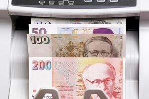 Israeli new shekel in the counting machine photo