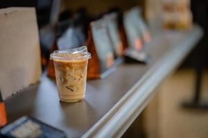 Close up and selective focus glass of ice latte on black table at coffee shop. photo