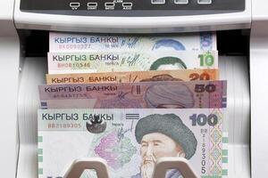 Old Kyrgyz som in the counting machine photo