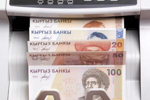 Old Kyrgyz som in the counting machine photo