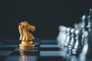 horse golden chess standing confront of the silver chess team.chess board game concept of business ideas and competition and stratagy plan success meaning photo