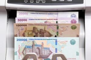 Uzbekistani sum in the counting machine photo