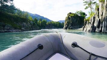 A boat is traveling down a river with a blue sky in the background. The water is calm and the trees lining the riverbank are lush and green. The boat is small and he is a motorboat photo
