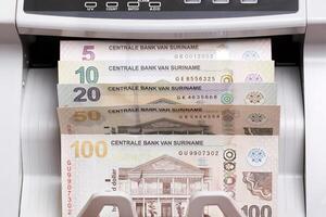 Surinamese dollar in the counting machine photo