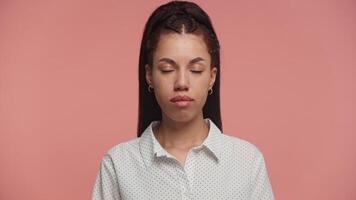 Woman with Serious Neutral Expression Against Pink Background video