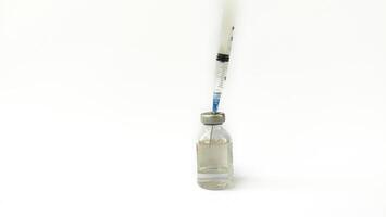 Vial of Drug or Vaccine and 3 ml Plastic Syringe with Needle Isolated on the White Background, blue tone color photo