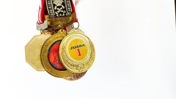 The winner's gold medal is held in the athlete's raised hand on a white background photo